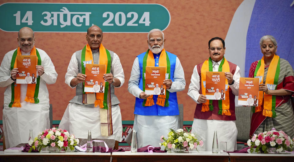 Indian Prime Minister Narendra Modi, center, releases his ruling Bharatiya Janata Party's manifesto for the upcoming national parliamentary elections in New Delhi, India, Sunday, April 14, 2024. Standing from L to R with him are BJP's senior leaders Home Minister Amit Shah, Defence Minister Rajnath Singh and Party President JP Nadda, and Finance Minister Nirmala Sitharaman. (AP Photo/Manish Swarup)