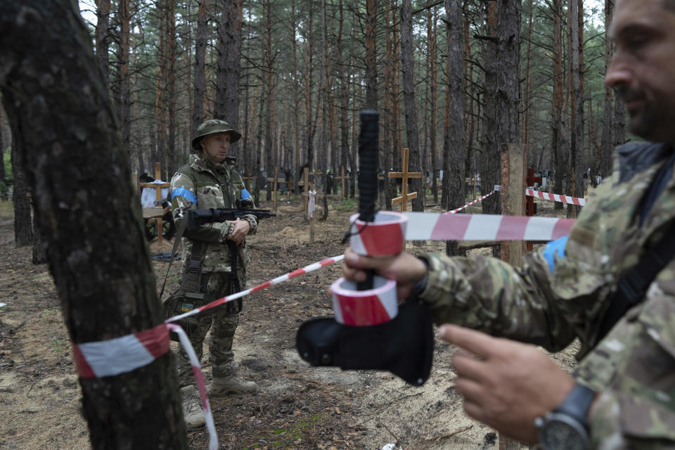 Oleg Kotenko, the Commissioner for Issues of Missing Persons under Special Circumstances, looks at the unidentified graves of civilians and Ukrainian soldiers in the recently retaken area of Izyum, Ukraine, September 15, 2022.  / Credit: Evgeniy Maloletka/AP