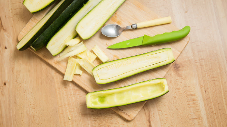 hollowing zucchini halves on table 