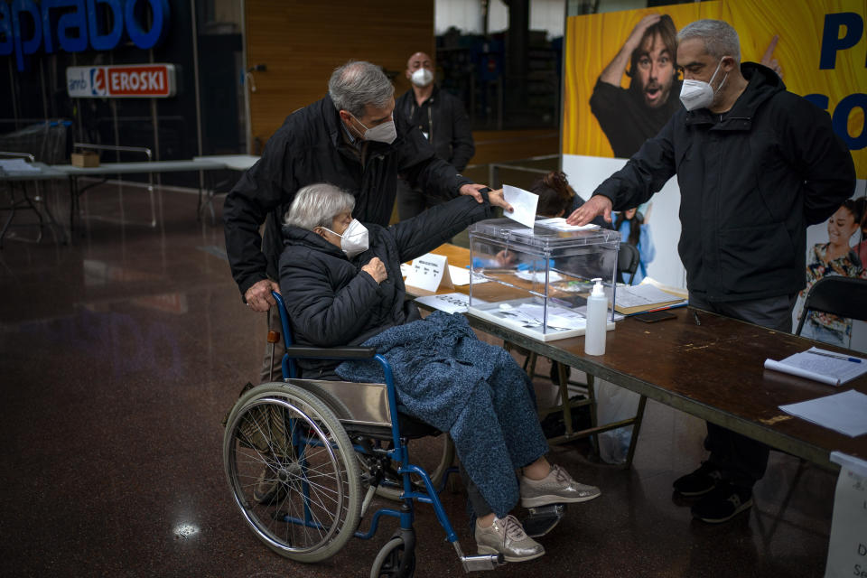 A woman casts her vote for the regional Catalan election at a polling station set up in a market in Barcelona, Spain, Sunday, Feb. 14, 2021. Over five million voters are called to the polls on Sunday in Spain's northeast Catalonia for an election that will measure the impact of the coronavirus pandemic on the restive region's secessionist movement. (AP Photo/Emilio Morenatti)