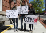 Siblings (from left to right) Tommy Kostelac, 15, Nathan Kostelac, 19, and Summer Kostelac, 17, pose for a portrait as they take part in a protest against lockdown measures put into place because of the coronavirus disease (COVID-19) outbreak and call for the reopening of the state in Richmond, Virginia, U.S., April 22, 2020. (REUTERS/Leah Millis)