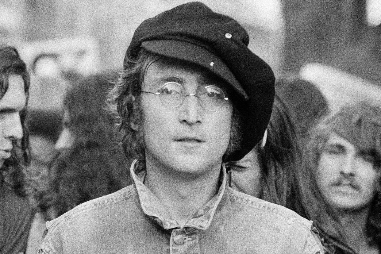 Portrait of British musician John Lennon (1940 - 1980) (center) and his wife, artist and musician Yoko Ono (extreme left) as they attend an unspecified rally in Hyde Park, London, England, 1975.