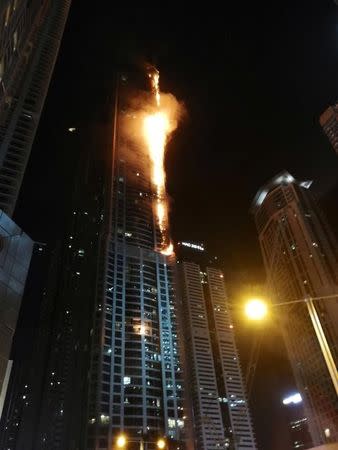 Flames shoot up the sides of the Torch tower residential building in the Marina district, Dubai, United Arab Emirates, in this August 4, 2017 picture by Mitch Williams. Mitch Williams/Social Media Website/via REUTERS