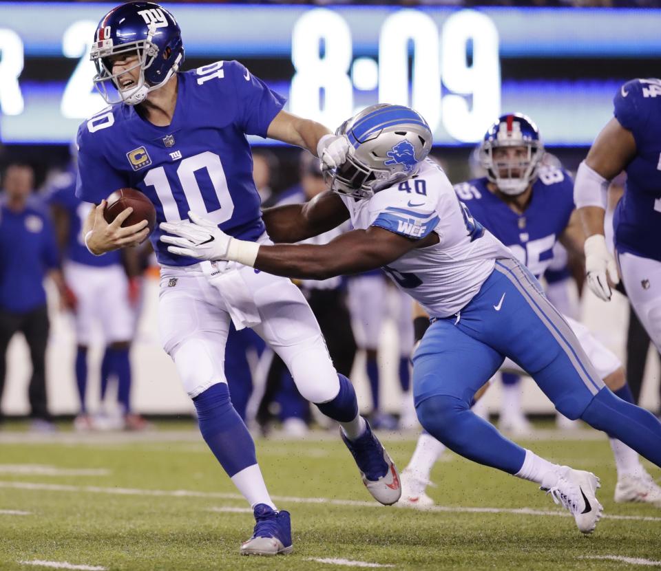 New York Giants quarterback Eli Manning (10) is sacked by Detroit Lions' Jarrad Davis (40). (AP)