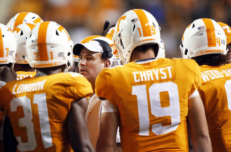 FILE- In this Sept. 22, 2018, file photo, Tennessee coach Jeremy Pruitt, center, talks to players during the second half of an NCAA college football game against Florida in Knoxville, Tenn. A planned scrimmage turned into a scaled-down practice at Tennessee last weekend when the Volunteers were without about 35 players due to COVID-19. Pruitt said seven or eight players were in isolation after being infected and another 28 or so had been quarantined after it was determined through contact tracing they had been exposed to the virus. (AP Photo/Wade Payne, File)