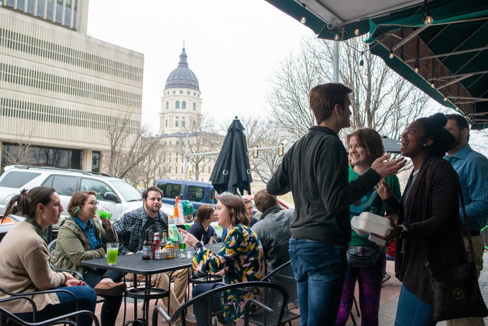 A group of young professionals in Topeka's Forge Young Talent group meet at a networking event in 2022. Kansas is losing too many of its young college-educated workers to other states, mostly because of relatively low salaries in the Sunflower State.