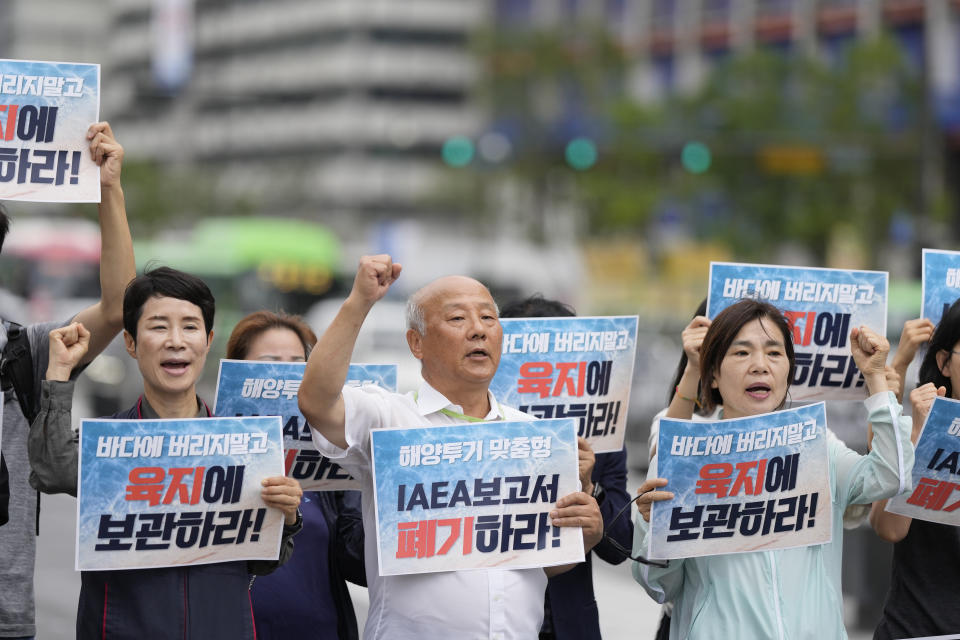 Members of civic groups shout slogans during a rally to oppose Japanese government's decision to release treated radioactive water into the sea from the Fukushima nuclear power plant, in Seoul, South Korea, Wednesday, July 5, 2023. The letters read "Abolish a report of the IAEA." (AP Photo/Lee Jin-man)