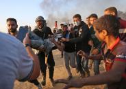 <p>Palestinians carry away a protester injured during clashes with Israeli forces along the border east of Khan Yunis in the southern Gaza Strip on May 15, 2018 after demonstrations marking 70th anniversary of Nakba — also known as Day of the Catastrophe in 1948 — and against the US’ relocation of its embassy from Tel Aviv to Jerusalem. (Photo: Said Khatib/AFP/Getty Images) </p>