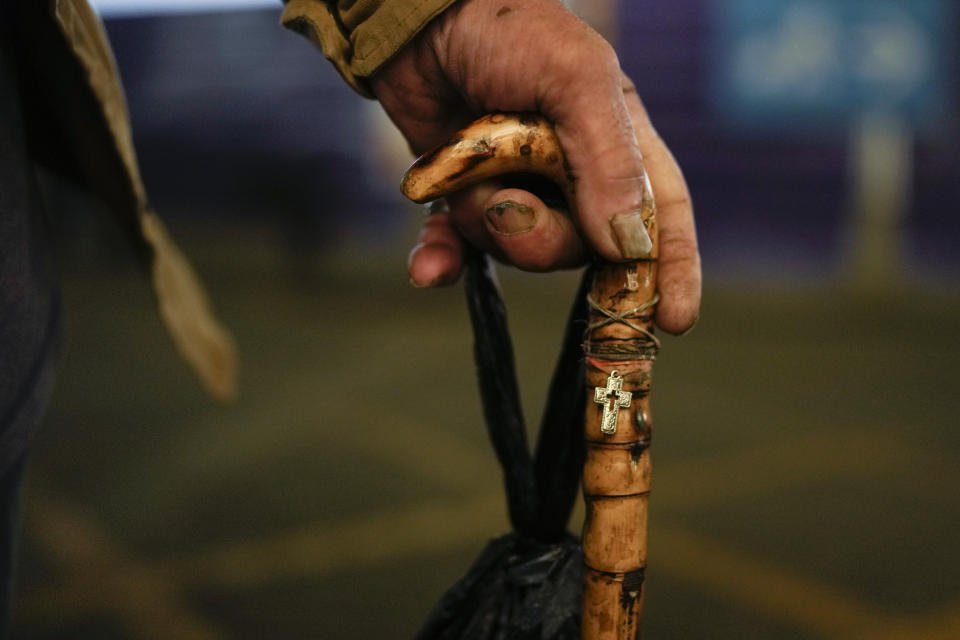 Angel Gomez holds his cane at the Jorge Newbery international airport, commonly known as Aeroparque, in Buenos Aires, Argentina, Thursday, April 6, 2023. Gomez, who is homeless, has made his Aeroparque his home where he sleeps each evening. (AP Photo/Natacha Pisarenko)