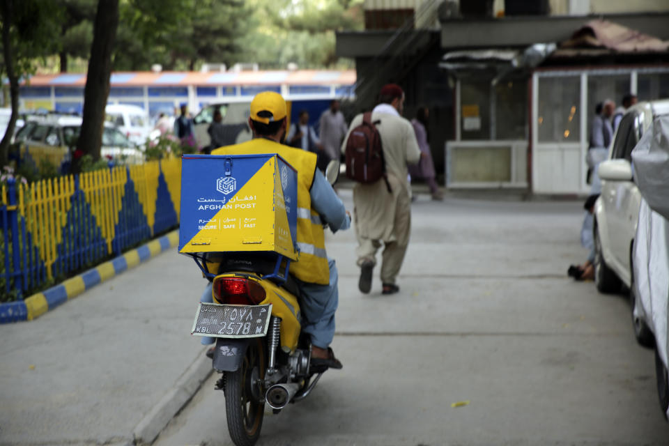 A postman travels on his bike for delivery in the city of Kabul, Afghanistan, Wednesday, July 3, 2024. In parts of Afghanistan where there are no street names or house numbers, utility companies and their customers have adopted a creative approach for connecting. They use mosques as drop points for bills and cash, a "pay and pray" system. (AP Photo/Siddiqullah Alizai)