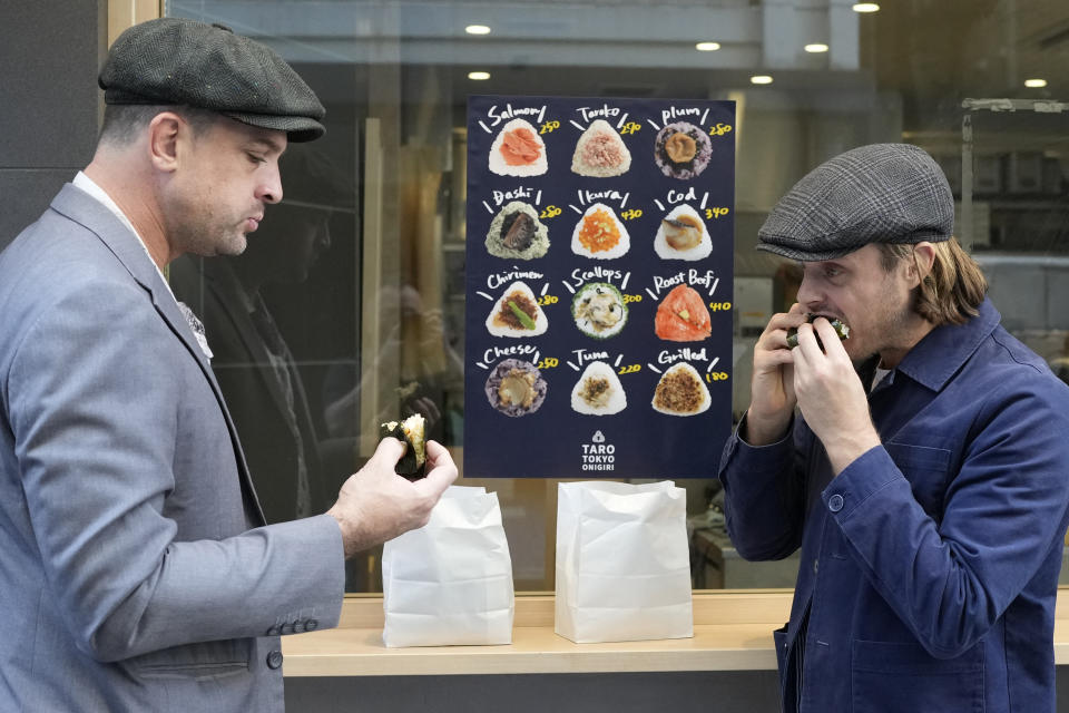 Tourists from Australia eat onigiri, rice balls, at a Taro Tokyo Onigiri shop in Tokyo, on June 5, 2024. The word "onigiri" just became part of the Oxford English Dictionary this year. The humble sticky-rice ball, a mainstay of Japanese food, has entered the global lexicon. (AP Photo/Shuji Kajiyama)