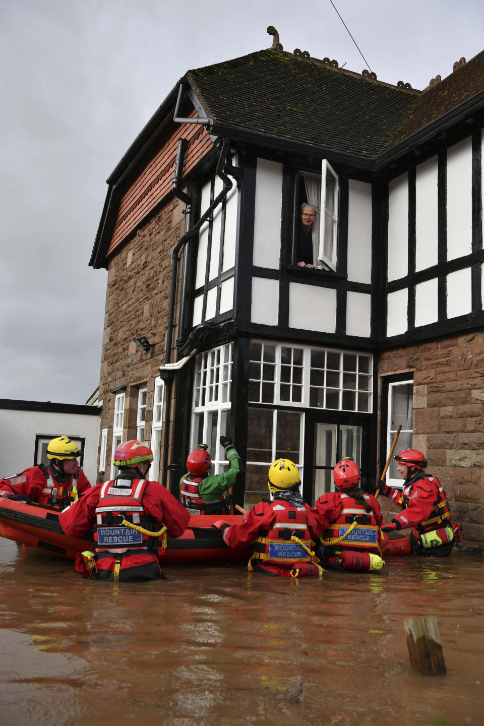 Mountain Rescue attempt to rescue a man from his house that is surrounded by floodwater in Monmouth, Wales, Tuesday Feb. 18, 2020. Britain's Environment Agency issued severe flood warnings Monday, advising of life-threatening danger after Storm Dennis dumped weeks' worth of rain in some places. (Ben Birchall/PA via AP)