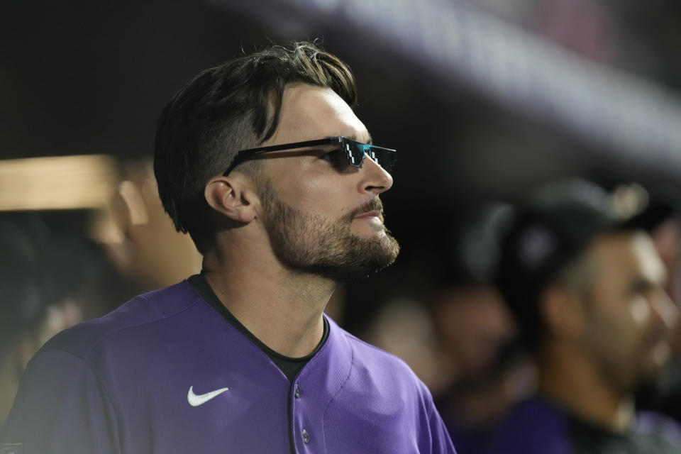 Colorado Rockies' Sam Hilliard dons a pair of home run shades as he returns to the dugout after hitting a two-run home run off Los Angeles Dodgers relief pitcher Alex Vesia in the seventh inning of a baseball game Wednesday, Sept. 22, 2021, in Denver. (AP Photo/David Zalubowski)