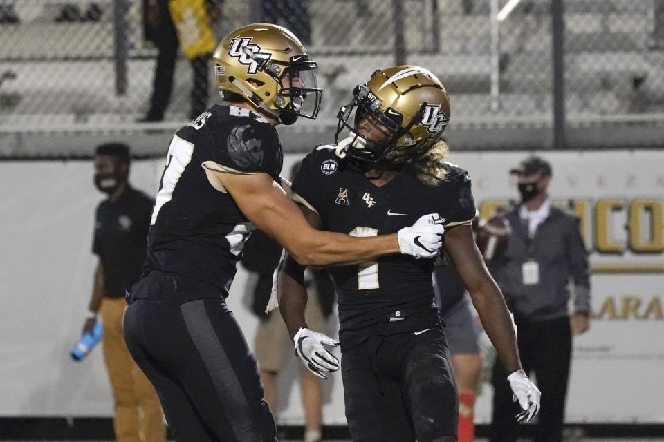 Central Florida wide receiver Jaylon Robinson, right, celebrates his 10-yard touchdown on a pass play against Cincinnati with teammate wide receiver Jacob Harris during the second half of an NCAA college football game, Saturday, Nov. 21, 2020, in Orlando, Fla. (AP Photo/John Raoux)