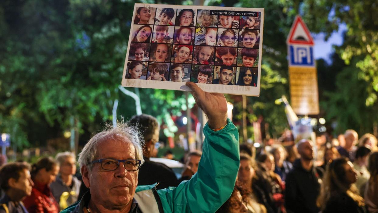  A man holds a sign with Israeli hostages. 