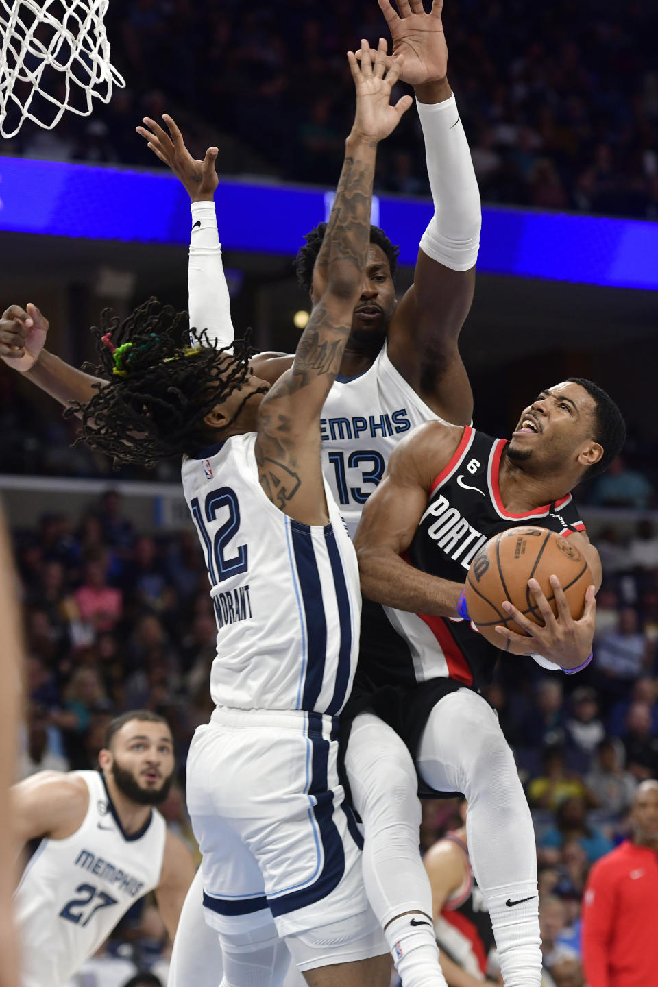 Portland Trail Blazers guard Shaq Harrison, right, shoots against Memphis Grizzlies guard Ja Morant (12) and forward Jaren Jackson Jr. (13) in the first half of an NBA basketball game Tuesday, April 4, 2023, in Memphis, Tenn. (AP Photo/Brandon Dill)