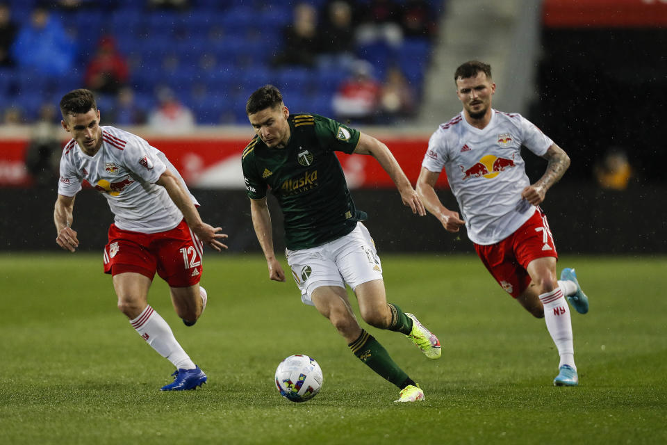 Portland Timbers forward Jaroslaw Niezgoda (11), center, tries to control the ball under the pressure of New York Red Bulls defenders Dylan Nealis (12) and Thomas Edwards (7) during the first half of an MLS soccer match, Saturday, May 7, 2022, in Harrison, N.J. (AP Photo/Eduardo Munoz Alvarez)