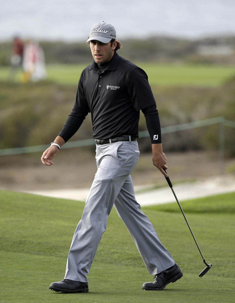 Andrew Loupe walks to retrieve his ball after making a birdie on the 14th green of the Monterey Peninsula Country Club Shore Course during the first round of the AT&T Pebble Beach Pro-Am golf tournament Thursday, Feb. 6, 2014, in Pebble Beach, Calif. (AP Photo/Eric Risberg)