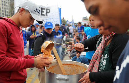 People receive a free meal at a soup kitchen set up on 9 de Julio avenue during a demonstration against the government’s economic measures in Buenos Aires, Argentina September 12, 2018. REUTERS/Marcos Brindicci