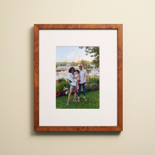 10 x 12 picture frame of a couple and their daughter hanging on a beige wall