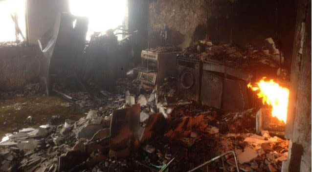 First pictures of the London tower's charred remains show a gutted kitchen as a fire still burns in the corner. Picture: Twitter