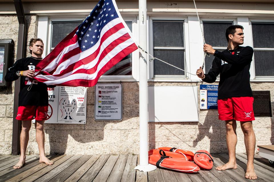 Members of the Rehoboth Beach Patrol raise the American flag at the start of day 1 of the Memorial Day Weekend at Rehoboth Beach in Rehoboth, Saturday, May 27, 2023.