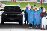 In this Friday, May 1, 2020, photo, medical workers flex their muscles as they pose for a photo at a drive-thru COVID-19 testing site in Waterloo, Iowa. (AP Photo/Charlie Neibergall)