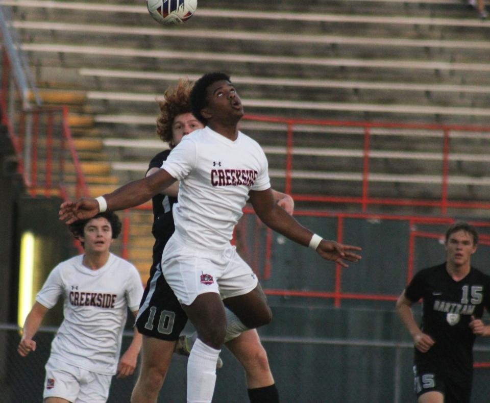 Creekside defender Bruno Alves (4) and Bartram Trail forward Danny Calvo (10) jump for a header during a FHSAA District 1-7A high school boys soccer semifinal on January 31, 2023. [Clayton Freeman/Florida Times-Union]