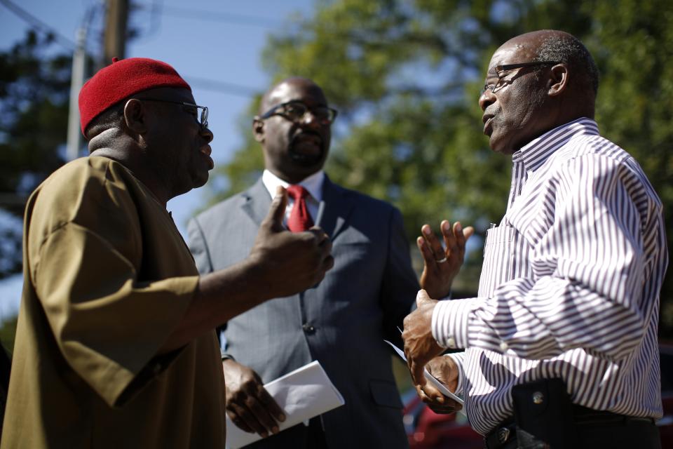 Steve Oriabure (R), Vice board Chairman of the Organization of Nigerian Nationals, speaks to Richard Nwachukwu (L), member of the Organization of Nigerian Nationals, and U.S. Congressional candidate Eric Williams after speaking to the media about their concerns on the impact of the Ebola crisis on the African communities in Dallas, Texas, October 4, 2014. REUTERS/Jim Young (UNITED STATES - Tags: HEALTH DISASTER)