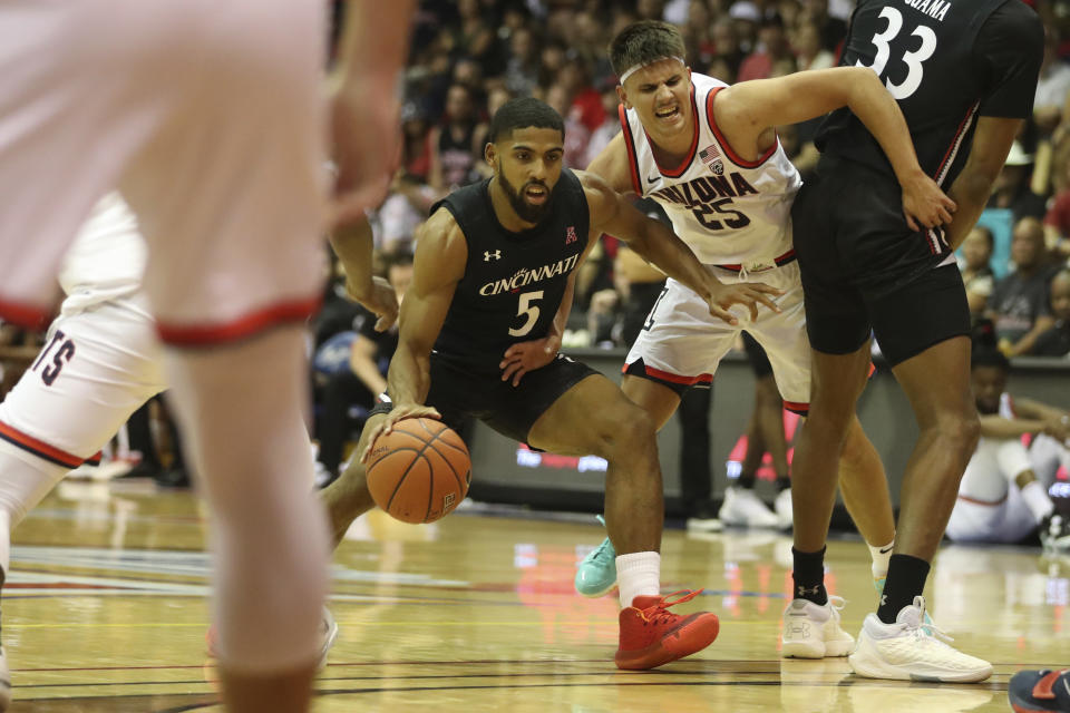 Arizona guard Kerr Kriisa runs into Cincinnati forward Ody Oguama while chasing guard David DeJulius (5 )during the first half of an NCAA college basketball game, Monday, Nov. 21, 2022, in Lahaina, Hawaii. (AP Photo/Marco Garcia)