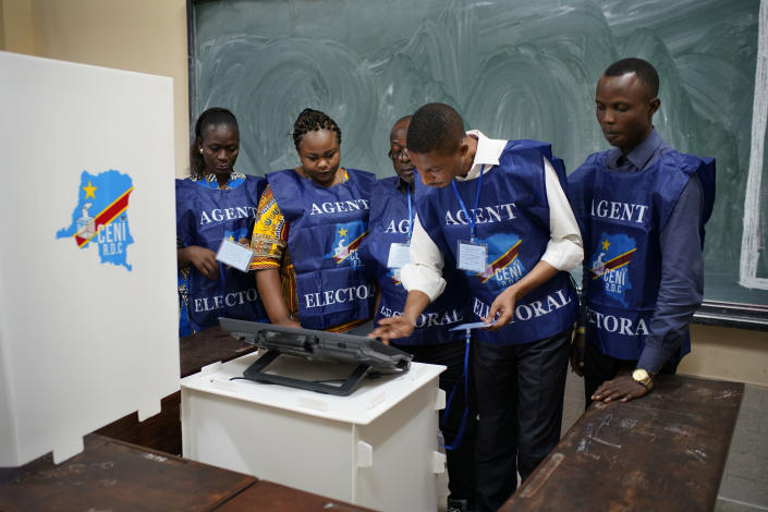 Congolese election officials get the voting machine ready before voting starts Sunday, Dec. 30, 2018 in Kinshasa, Congo. Forty million voters are registered for a presidential race plagued by years of delay and persistent rumors of lack of preparation. (AP Photo/Jerome Delay)