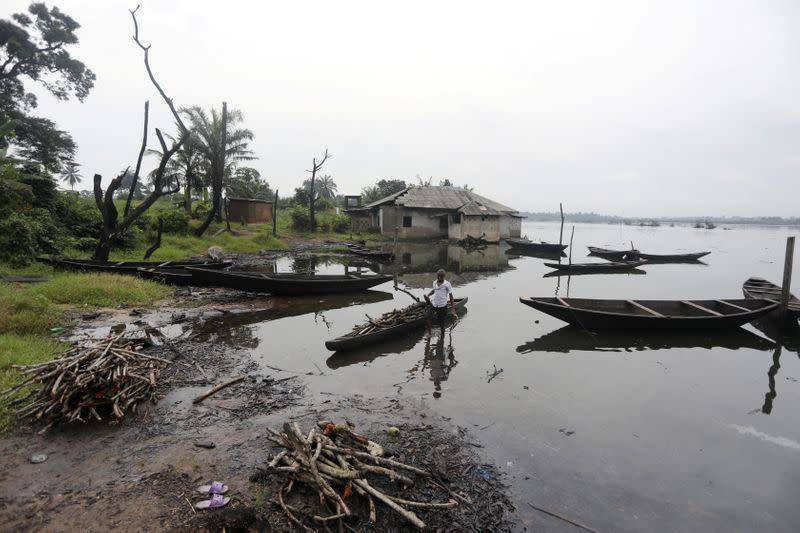 A man removes pieces of wood from a canoe in Ogoniland, Rivers State