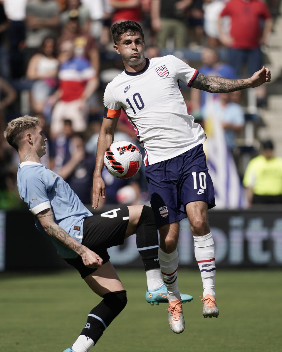 Uruguay defender Guillermo Varela (4) and USA forward Christian Pulisic (10) battle for the ball during the first half of an international friendly soccer match Sunday, June 5, 2022, in Kansas City, Kan. (AP Photo/Charlie Riedel)