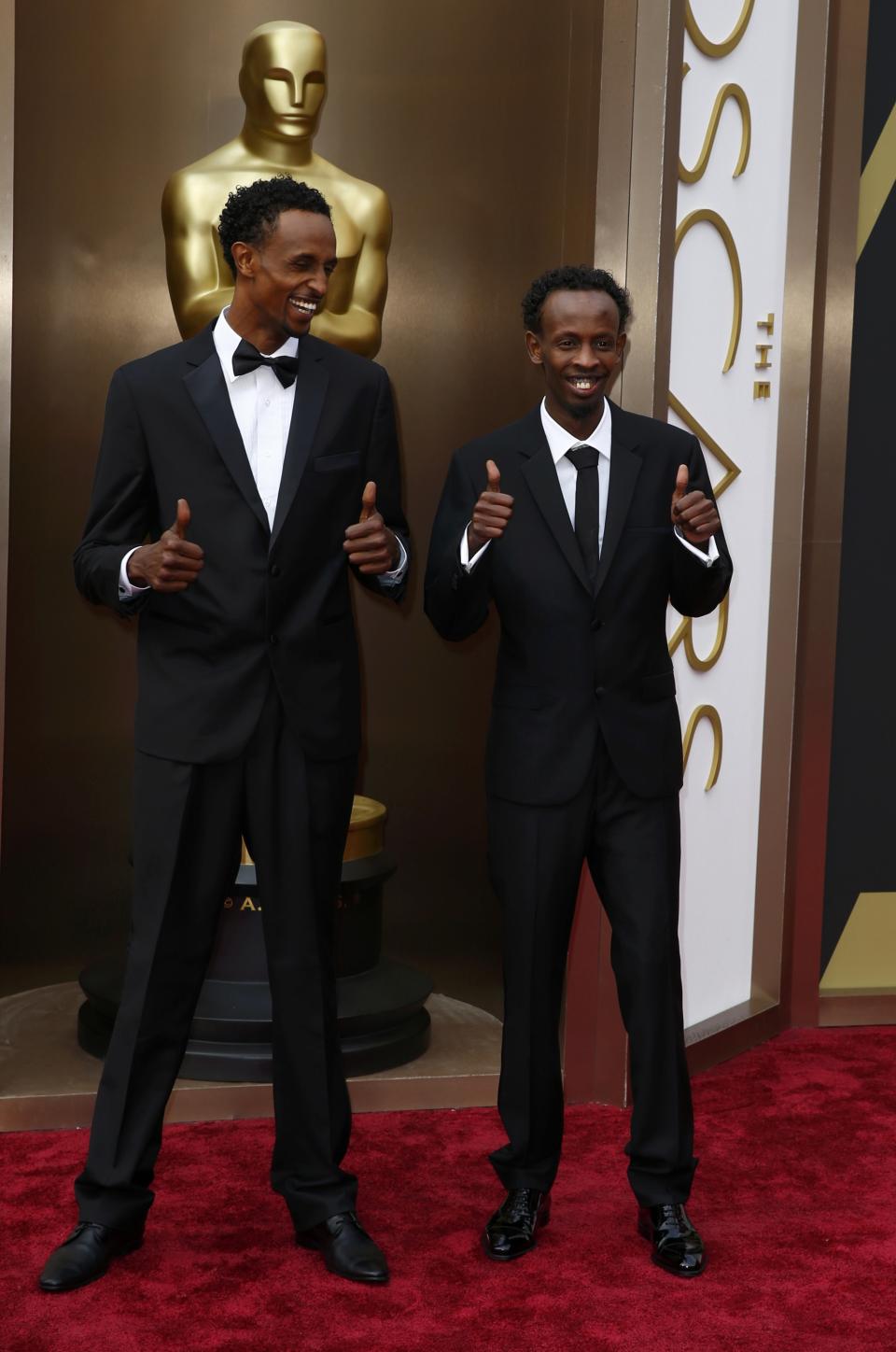 Barkhad Abdi (R), best supporting actor nominee for his role in "Captain Phillips," arrives with actor Faysal Ahmed at the 86th Academy Awards in Hollywood, California March 2, 2014. REUTERS/Lucas Jackson (UNITED STATES - Tags: ENTERTAINMENT) (OSCARS-ARRIVALS)