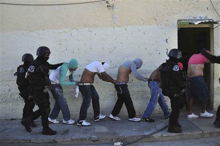 Inmates are escorted by riot policemen during an operation after a gunfight at the Tuxpan prison in Iguala, in the Mexican State of Guerrero January 3, 2014. REUTERS/Jesus Solano