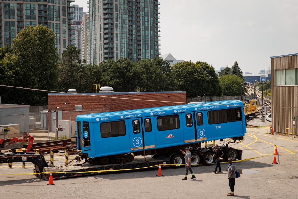 Transit workers are pictured at the McCowan transit yard on July 25, 2023 after a Scarborough Rapid Transit train car derailed a day earlier. The car was awaiting inspection. (Evan Mitsui/CBC - image credit)