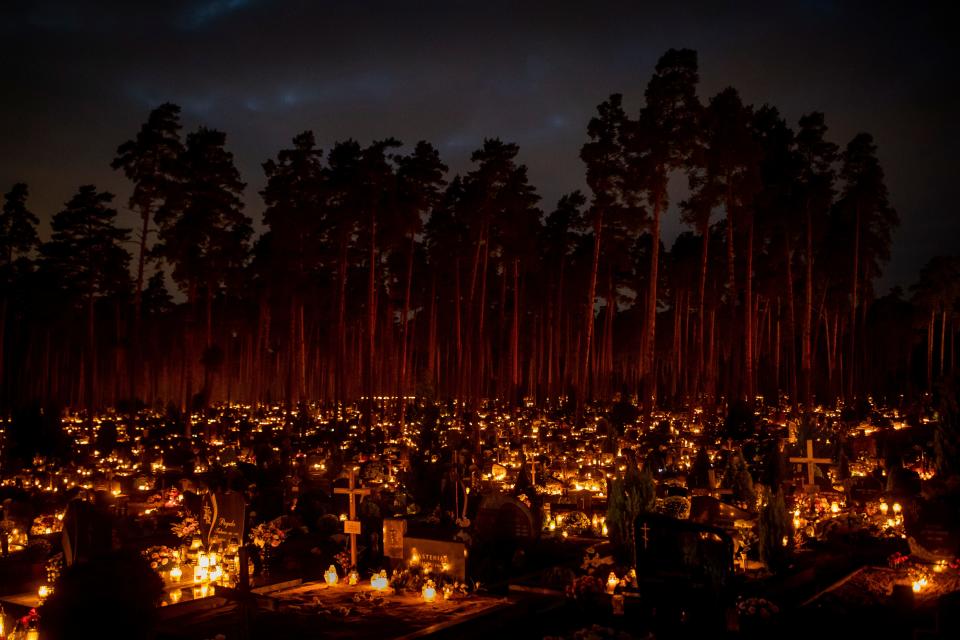 Candles are lit during All Saints Day at the cemetery in Vilnius, Lithuania, Tuesday, Nov. 1, 2022. Candles illuminated tombstones in graveyards across Europe as people communed with the souls of the dead on Tuesday, observing one of the most sacred days in the Catholic calendar.