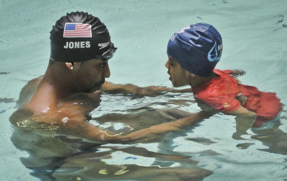 This May 17, 2013 photo released by Simone Smalls PR shows Olympic gold medalist Cullen Jones give swimming lessons to Niko Diop, a pre-kindergarden student at Harlem's P.S. 125 in New York. Jones is ambassador for the 5th Annual USA Swimming Foundation's "Make a Splash Tour," providing free swimming lessons, water safety education and awareness at city pools. (AP Photo/Simone Smalls PR)