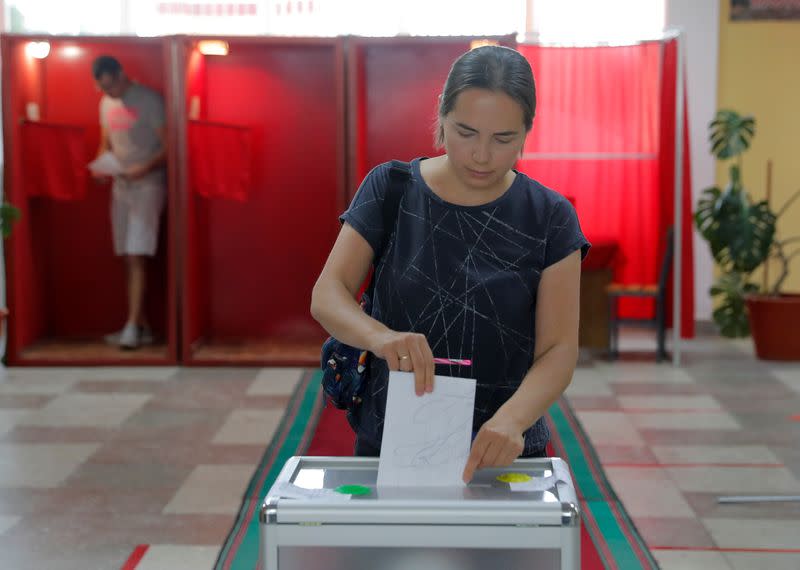 A voter casts her ballot at a polling station during the presidential election in Minsk