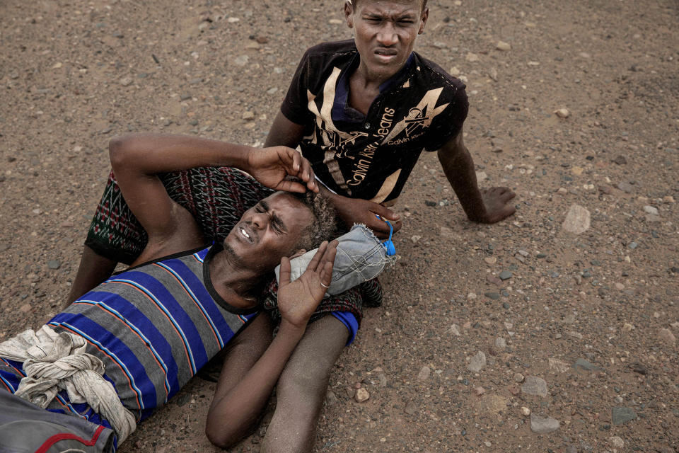 In this July 23, 2019 photo, Ethiopian migrants lie on the ground because of a sandstorm in Lahj, Yemen. According to the U.N.'s International Organization for Migration, 150,000 arrived in Yemen from the Horn of Africa in 2018, a 50% jump from the year before. The number in 2019 was similar. They dream of reaching Saudi Arabia, and earning enough to escape poverty by working as laborers, housekeepers, servants, construction workers and drivers. (AP Photo/Nariman El-Mofty)