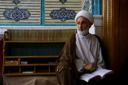 Abdul Hussain Jassim Al Aboudi, 60, a student at al-Gharawiya school run by al-Hawza al-Ilmiyya, holds a book, in Najaf, Iraq, August 13, 2017. For more than 1,000 years, the al-Hawza al-Ilmiyya in southern Baghdad has been giving religious instructions to thousands of Shi'ite Muslims to help them become clerics. REUTERS/Abdullah Dhiaa Al-deen