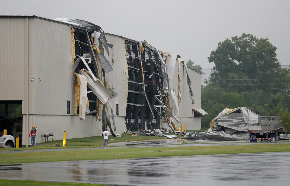 In this Saturday, June 15, 2019, photo people look storm damage at the Alro Steel metals in Beech Grove, Ind., after a tornado moved through the area. Weather officials say severe storms in central Indiana caused floods and produced several tornadoes. (Matt Kryger/The Indianapolis Star via AP)