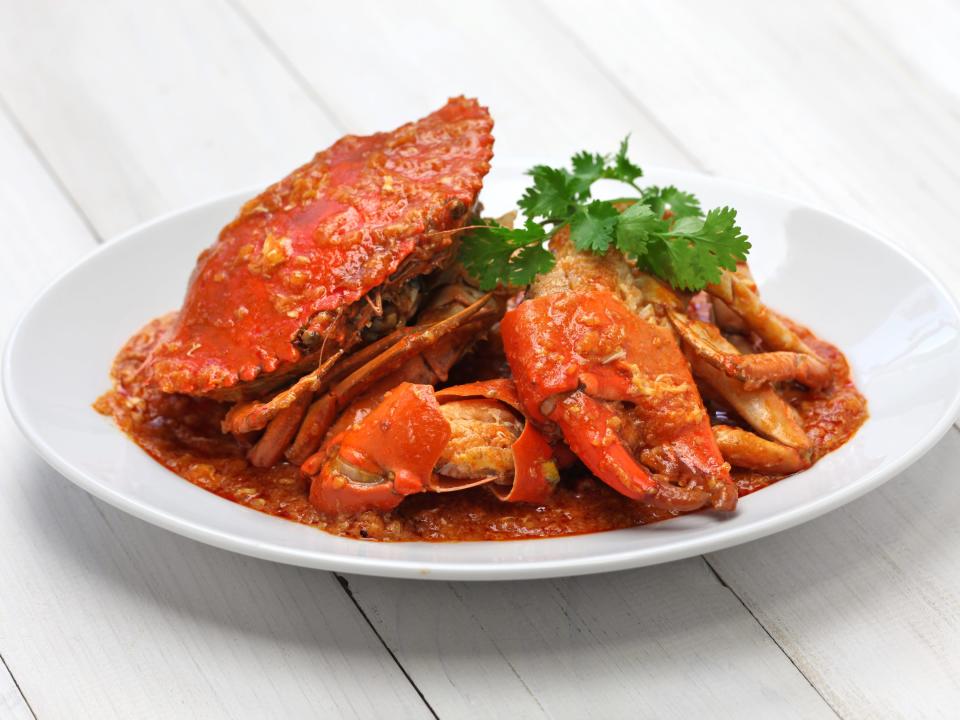 Singaporean chili crab served on a white plate.