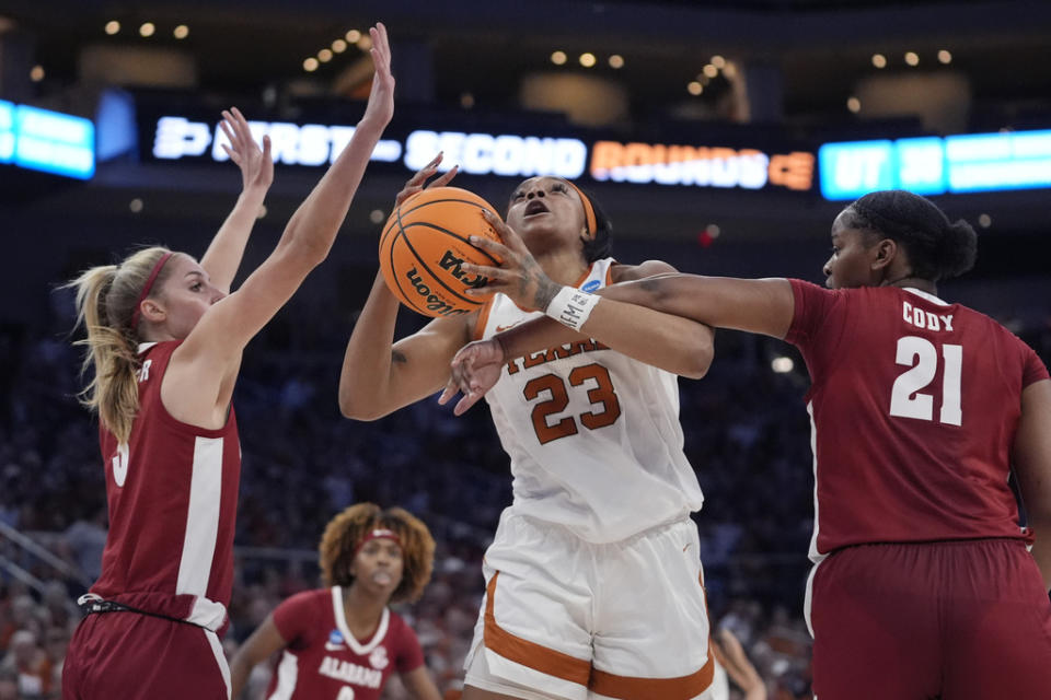 Texas forward Aaliyah Moore (23) is fouled by Alabama forward Essence Cody (21) as she tries to shoot during the first half of a second-round college basketball game in the women’s NCAA Tournament in Austin, Texas, Sunday, March 24, 2024. (AP Photo/Eric Gay)