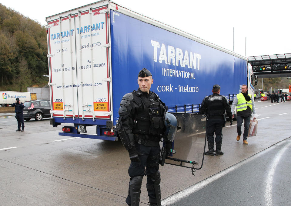 A French police officer secures the border with Spain as demonstrators wearing yellow vests blocked the highway near the French border during a protest Saturday, Dec. 15, 2018, in Biriatou, southwestern France. Police have deployed in large numbers Saturday for the fifth straight weekend of demonstrations by the "yellow vest" protesters, with authorities repeating calls for calm after protests on previous weekends turned violent.(AP Photo/Bob Edme)