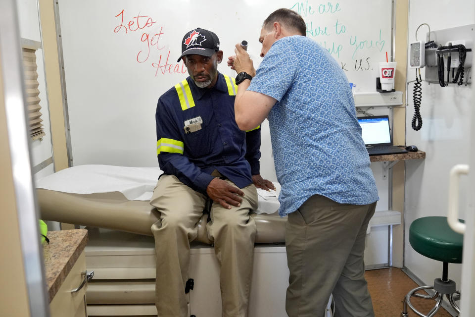 Dr. Matt Essary checks on a patient as he works at one of the five Circle The City mobile clinics stationed outside soup kitchens and other services for homeless people, Thursday, May 30, 2024 in Phoenix. Based in the hottest big metro in America, Circle the City is taking measures to protect patients from life-threatening heat illness as temperatures hit new highs. Homeless people accounted for nearly half of the record 645 heat-related deaths last year in Arizona's Maricopa County, which encompasses metro Phoenix.(AP Photo/Matt York)