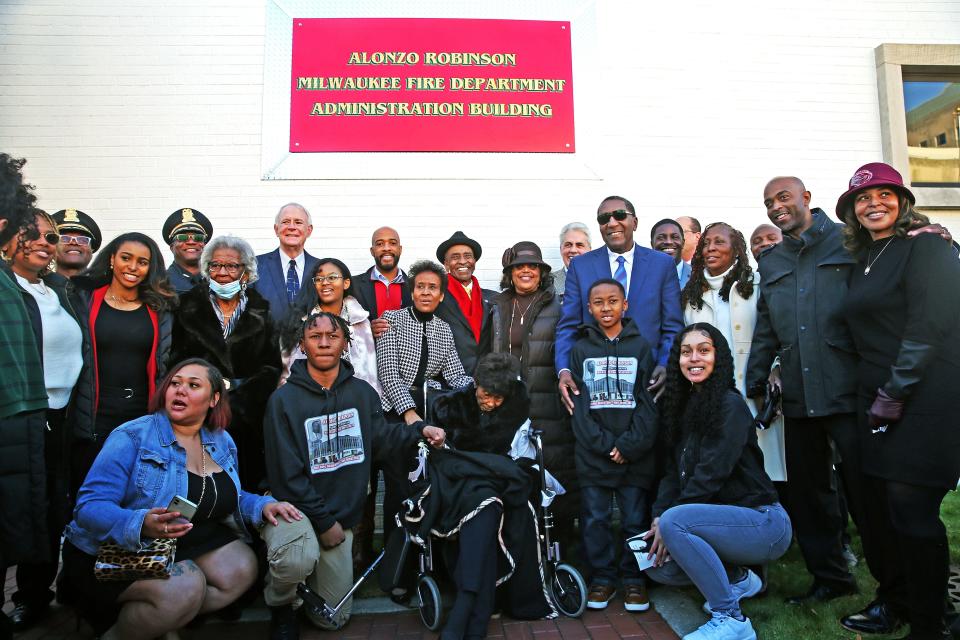 Theresa Robinson, center, the widow of Alonzo Robinson, is joined by her family, friends and local officials following the renaming of the Milwaukee Fire Department Administration Building that is now named after her husband  on Tuesday.