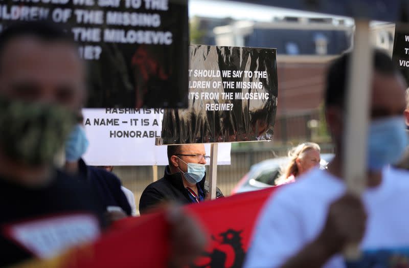 People hold signs as show support for Kosovo's President Hashim Thaci in front of the special tribunal, in The Hague