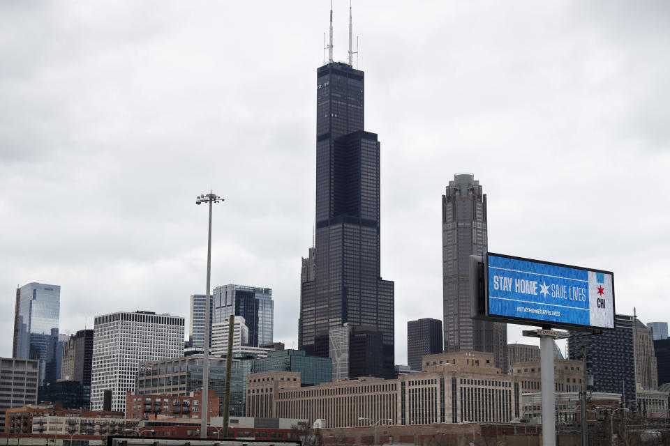 A public service message Stay Home Saves Lives is seen against the Chicago skyline Monday, March 30, 2020. The new coronavirus causes mild or moderate symptoms for most people, but for some, especially older adults and people with existing health problems, it can cause more severe illness or death. (AP Photo/Charles Rex Arbogast)