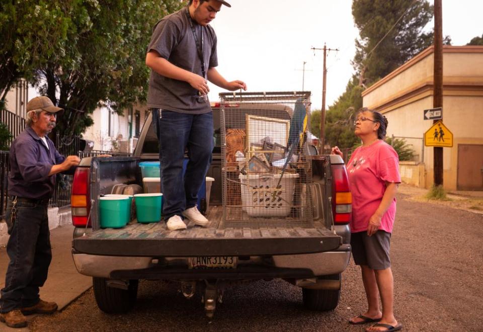 Ralph Garcia, left, Josiah Arvizu and Patsy Arvizu load up their truck on Monday while evacuating from the Telegraph fire in Miami, Arizona.